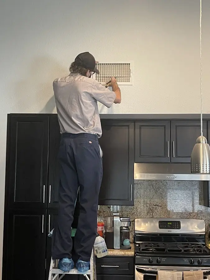 Technician inspecting an air vent during HVAC service in Irmo